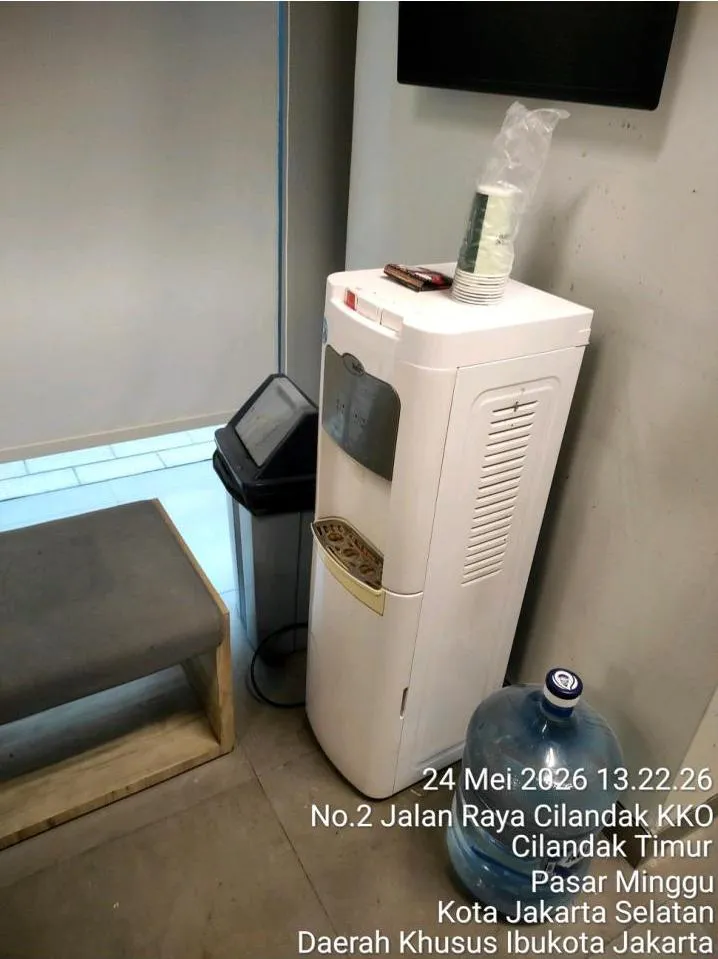 Dispenser air terpasang di sudut area kantor PT Herbalife Indonesia sebelum maintenance dispenser dilakukan, lengkap dengan galon cadangan di sampingnya