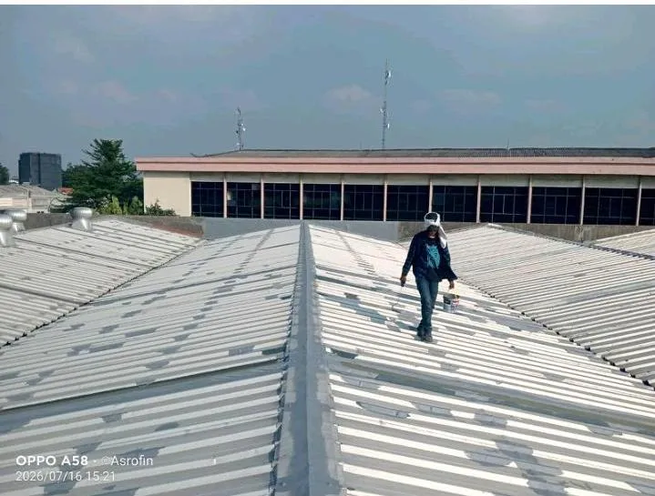 Teknisi Sejasa berjalan di atas atap spandek bentang lebar gudang hub Lalamove Daan Mogot saat pengecekan kebocoran
