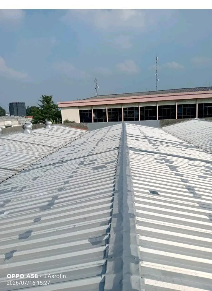 Pertemuan talang dan atap spandek gudang dengan pelapisan anti bocor menutup jalur sambungan yang menjadi sumber kebocoran
