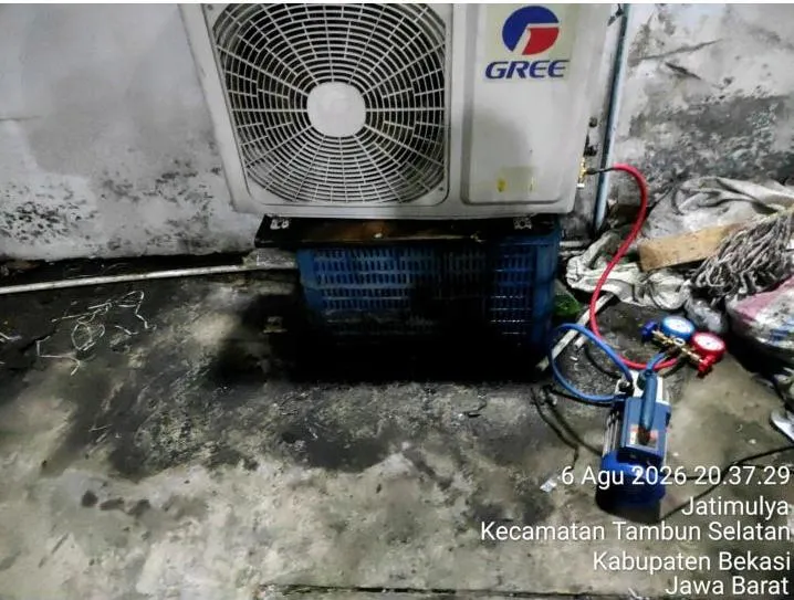 Pompa vakum dan manifold gauge terpasang pada unit outdoor AC Gree saat proses vacuum flushing dan penanganan jalur refrigeran