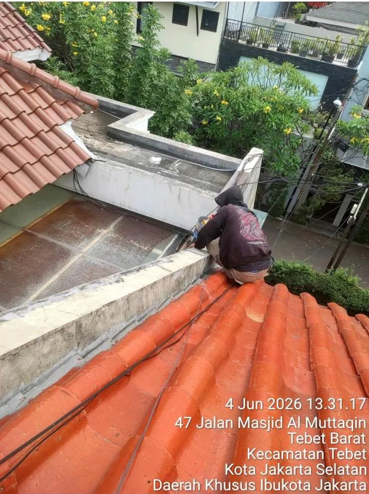 Teknisi Sejasa menutup celah pertemuan dinding atap dan genteng saat perbaikan kebocoran di lokasi CV Lessalt Jakarta Sehat, Tebet