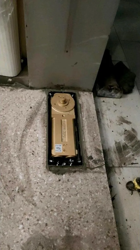 Floor hinge pintu kaca terpasang pada dudukan di lantai setelah pintu ditata ulang posisinya