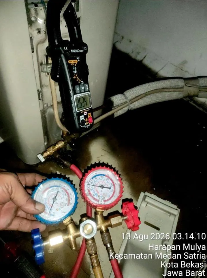Pengecekan tekanan refrigeran dengan manifold gauge dan pengukuran arus listrik dengan clamp meter pada unit AC