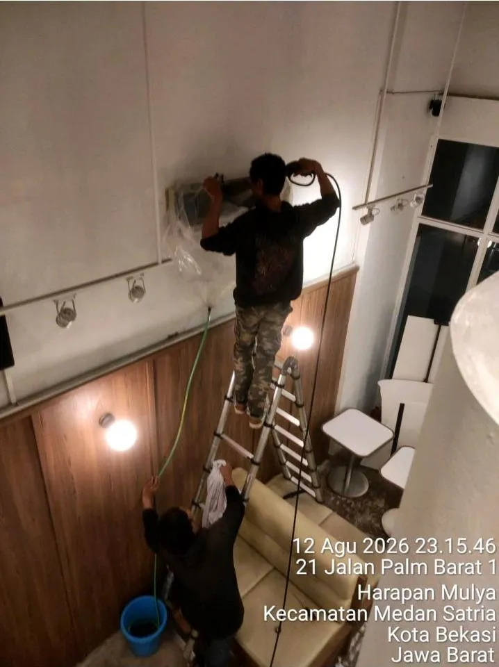 Dua teknisi Sejasa mengerjakan service AC pada unit indoor yang terpasang tinggi di area dine-in Grainsly Summarecon Bekasi