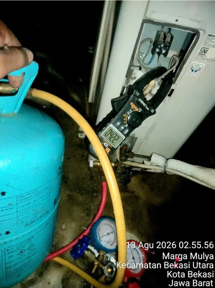 Tabung refrigeran, manifold gauge, dan clamp meter disiapkan untuk penambahan freon pada unit outdoor AC