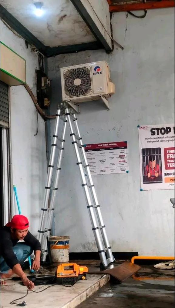 Unit outdoor AC di gerai SiCepat Bekasi Tarumajaya disiapkan sebelum proses cuci AC, dengan tangga dan mesin cuci bertekanan di area kerja