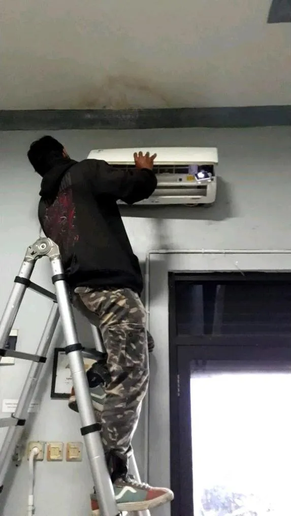 Teknisi Sejasa membuka casing unit indoor AC split wall saat proses cuci AC di gerai SiCepat Bekasi Tarumajaya
