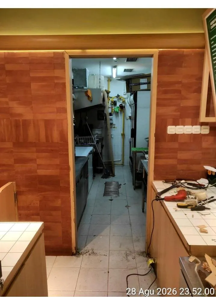 Daun pintu kitchen dilepas saat bongkar pasang, memperlihatkan kusen dan akses dapur outlet dengan peralatan kerja tim Sejasa
